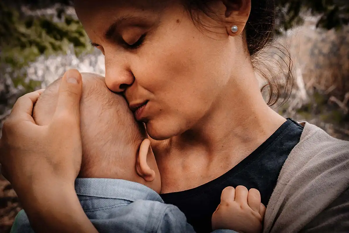 Mutter mit Baby auf dem Arm newborn Fotografie im warmen Licht