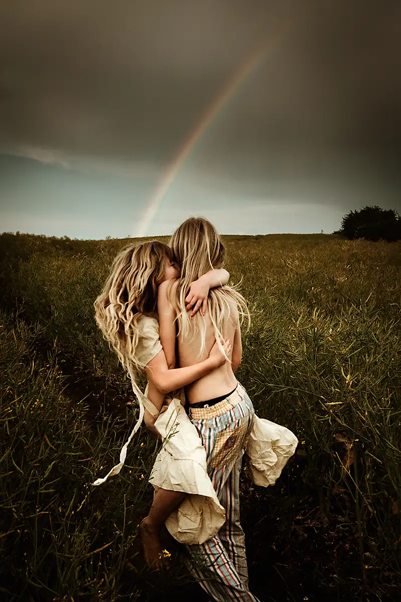 wundeschöne Geschwisterfotos der beiden Kinder vor dem Regenbogen