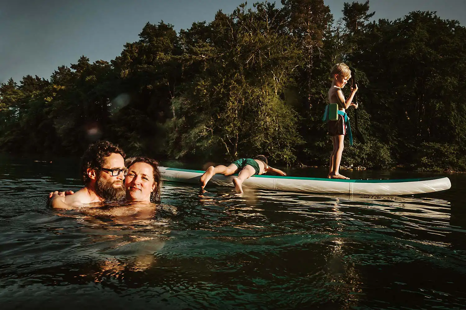 Kinder paddeln während die Eltern im See träumen outdoof fotografiert