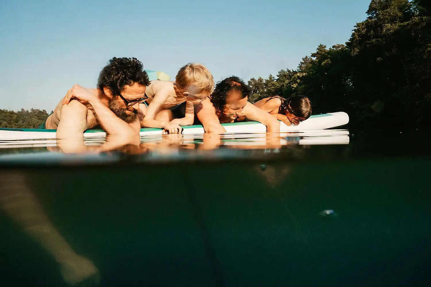 familien entspannt sich bei der Fotosssion auf dem SUP im Wasser