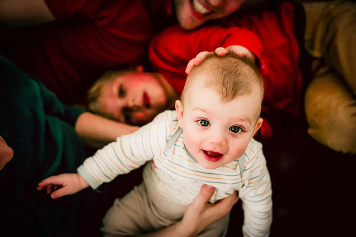 kleines KInd im Kreise der Familien in den eigenen vier Wänden