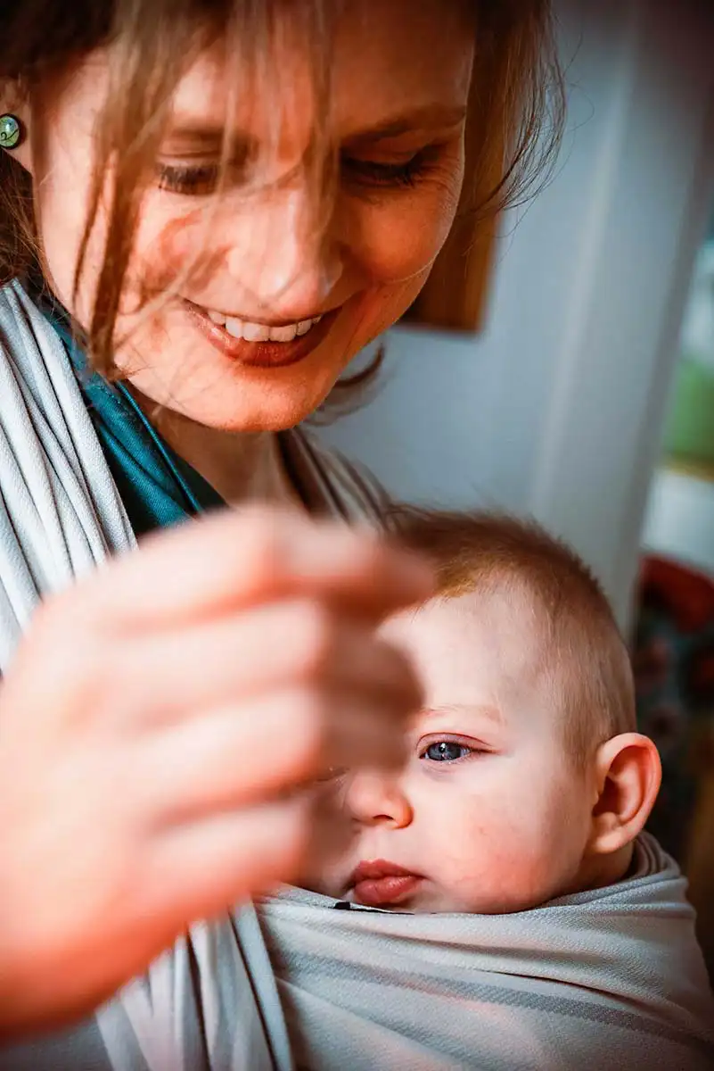 Mutterglück ind der Familienfotossession mit Kleinkind lächelnd