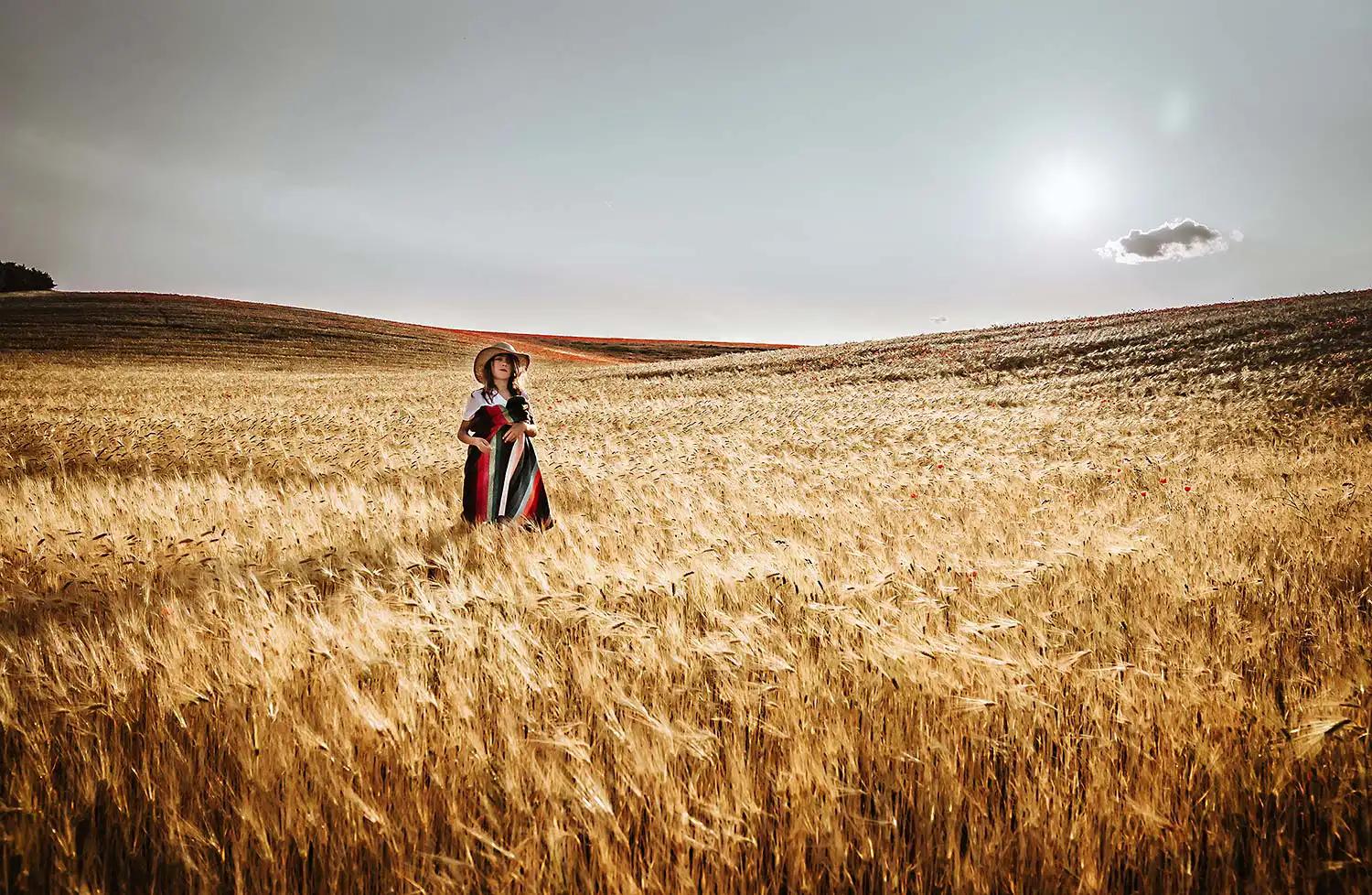 Junge steht im Gegenlicht beim Life Style Shooting mitten im Kornfeld bei hochsommerlichen Temperaturen