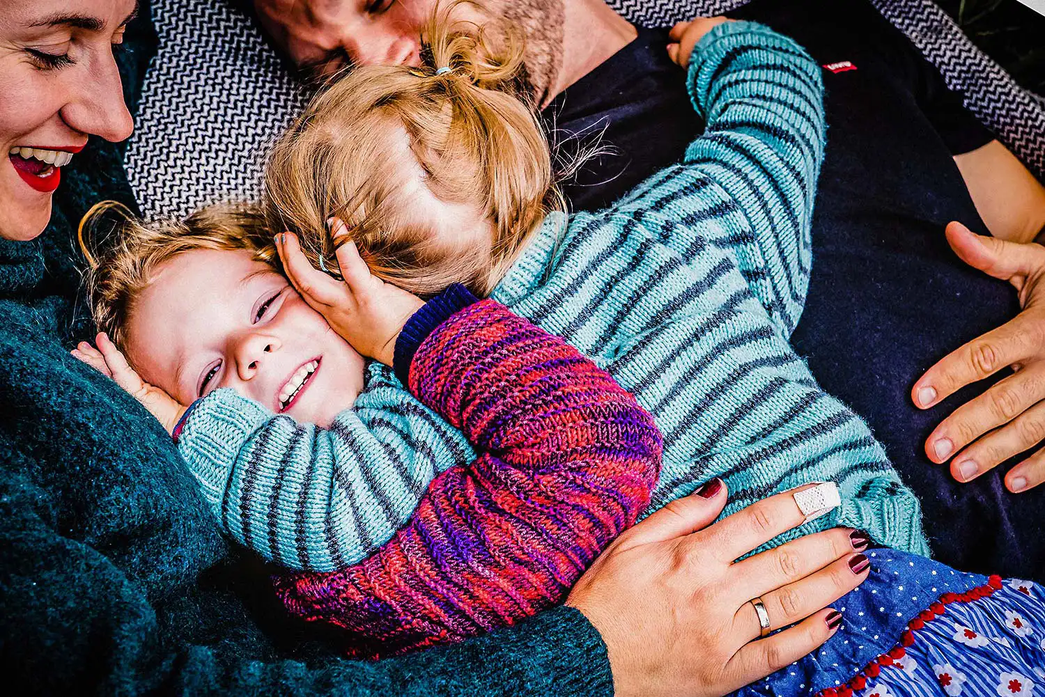 Die Fotografie zeigt die kuschelige Stimmung in der Familie auf der Wiese