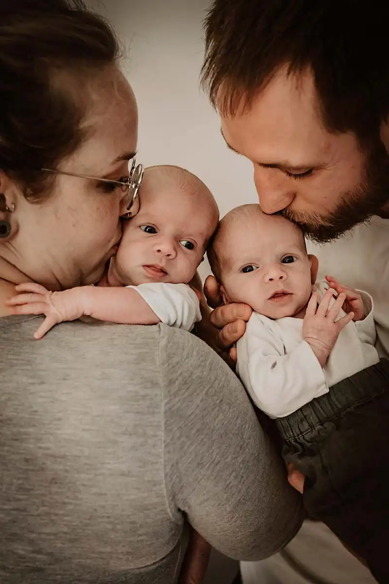 Zauber der Newborn Fotografie Session mit schmusenden jungen Eltern