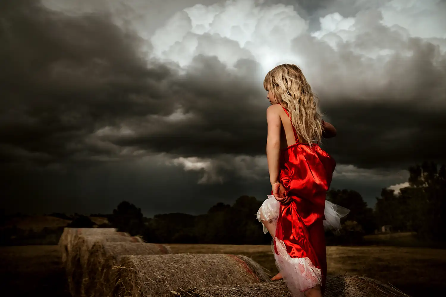 Mädchen mit rotem Kleid vor beeindruckenden Wolken