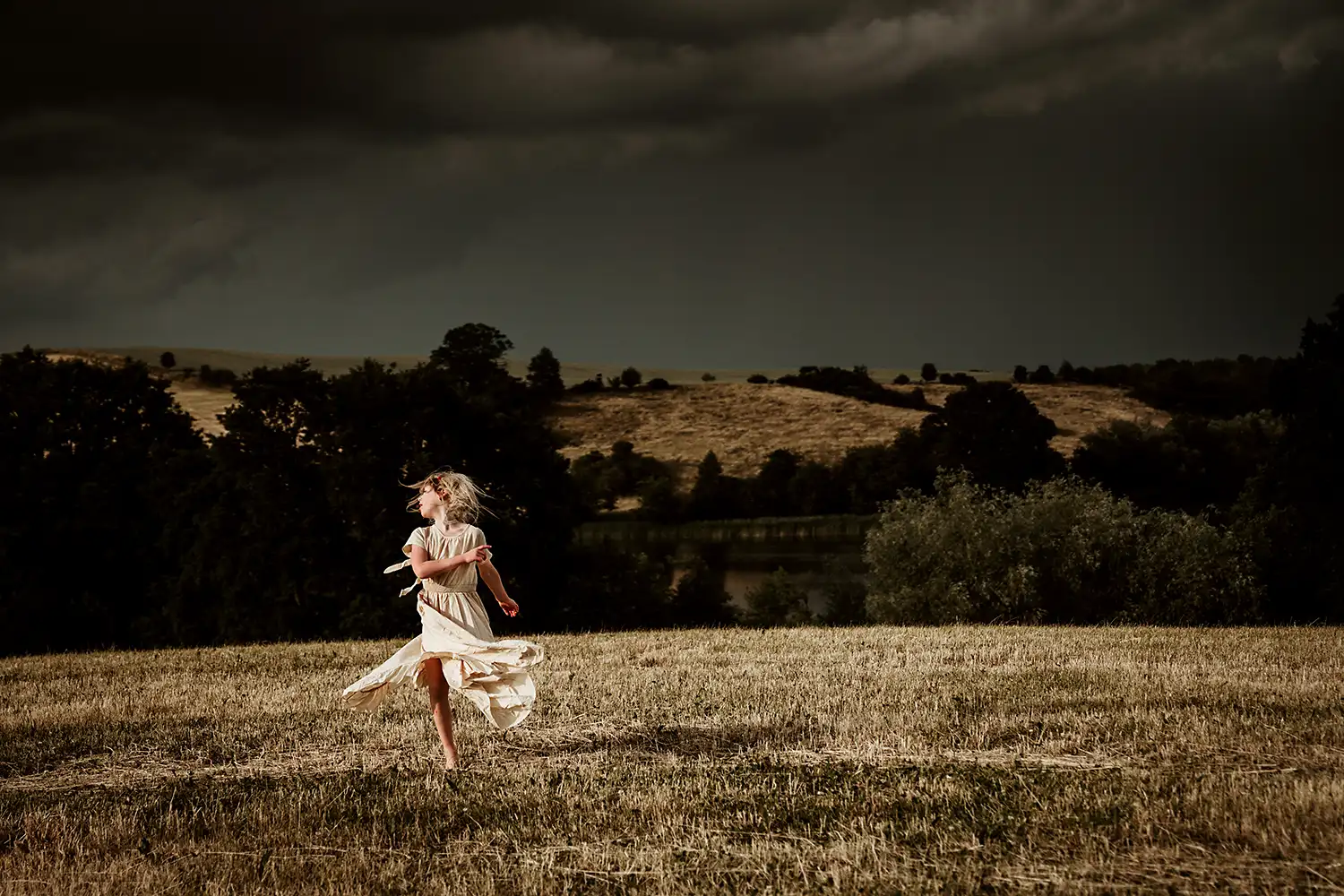 fröhlich laufend hüpfendes Kind im Boho Style Kleid beim Fotoshooting in der Uckermark