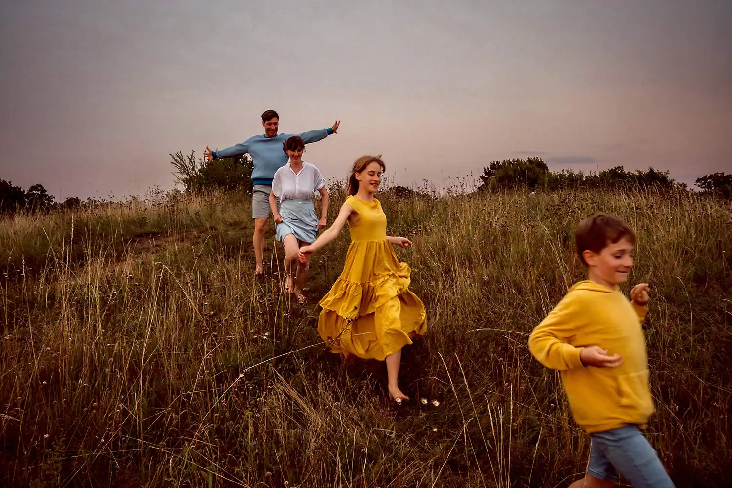 Abschlussfoto des Familien Shooting mit zügig laufende Familie über die Wiese in der Uckermark